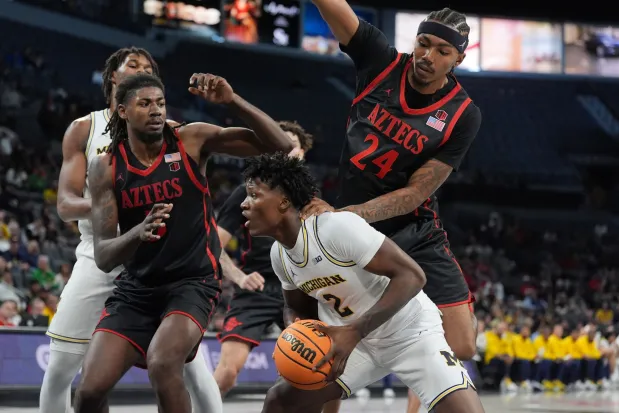 Michigan guard L.J. Cason (2) is pressured by San Diego State guard Taj Degourville (24) and San Diego State forward Pharaoh Compton, left, during the first half of an NCAA college basketball game in Las Vegas, Monday, Nov. 24, 2025. (AP Photo/Eric Gay)