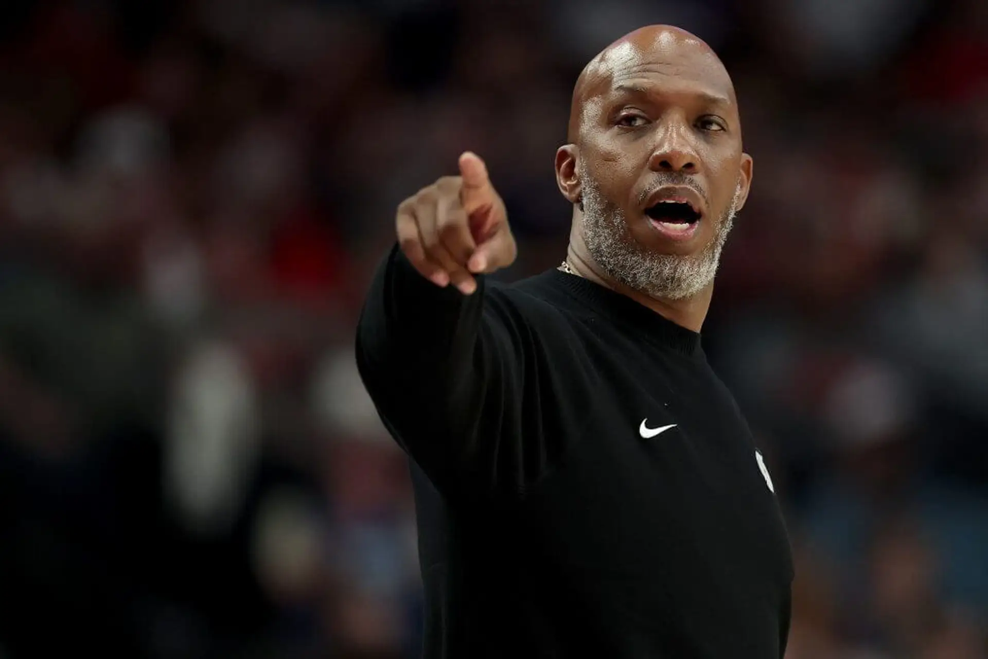 Chauncey Billups points during a basketball game.
