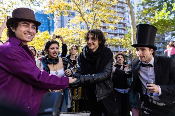 Miles Mitchell, left and Zander Dueve, center, shake hands at the Timothee Chalamet lookalike contest in New York on Oct. 27, 2024. (AP Photo/Stefan Jeremiah, File)