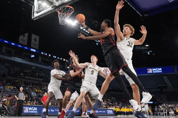 San Diego State forward Jeremiah Oden (25) drives to the basket past Michigan center Malick Kordel (32) during the second half of an NCAA college basketball game in Las Vegas, Monday, Nov. 24, 2025. (AP Photo/Eric Gay)