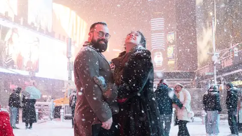 People take photos with the snow in Times Square on Feb. 22, 2026, in New York, New York. (Photo by Noam Galai/Getty Images)