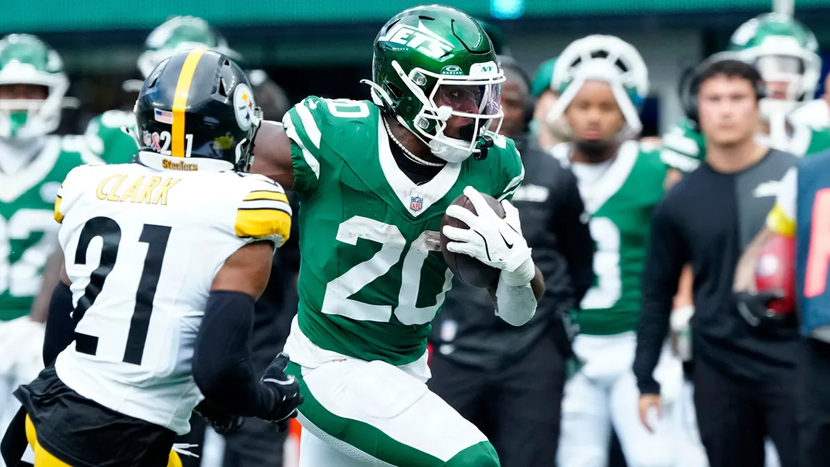 Breece Hall runs up the sideline