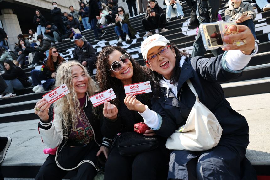 Fans who couldn't get tickets take selfies with fan-made tickets for souvenir at Gwanghwamun Square that will be the site of BTS' comeback concert.