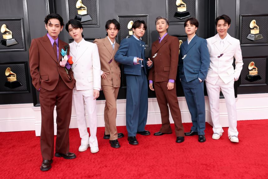 BTS (from left: V, Suga, Jin, Jungkook, RM, Jimin and J-Hope) made a striking red carpet appearance at the 64th Annual Grammy Awards in April 2022, wearing custom-made, color-coordinated Louis Vuitton suits, serving then as house ambassadors.