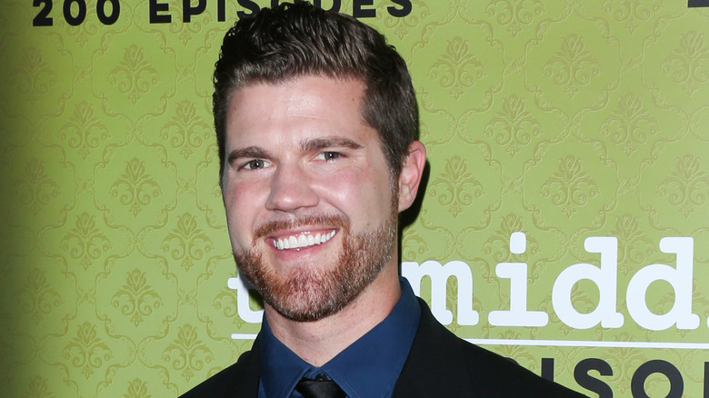 Actor Beau Wirick smiling on the red carpet at the celebration of the 200th episode of The Middle in a black suit